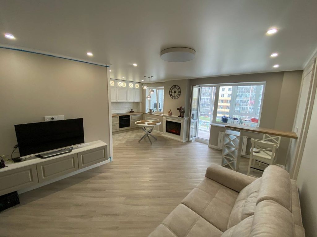 Готовый ремонт кухни-гостиной в светлых тонах: встроенный гарнитур, электрокамин и барная стойка. Пример нашей отделки квартиры в новостройке г. Томск