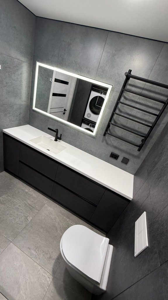 Современный дизайн ванной комнаты в серых тонах с подвесной черной тумбой и зеркалом с LED-подсветкой — пример нашего ремонта в г. Томск