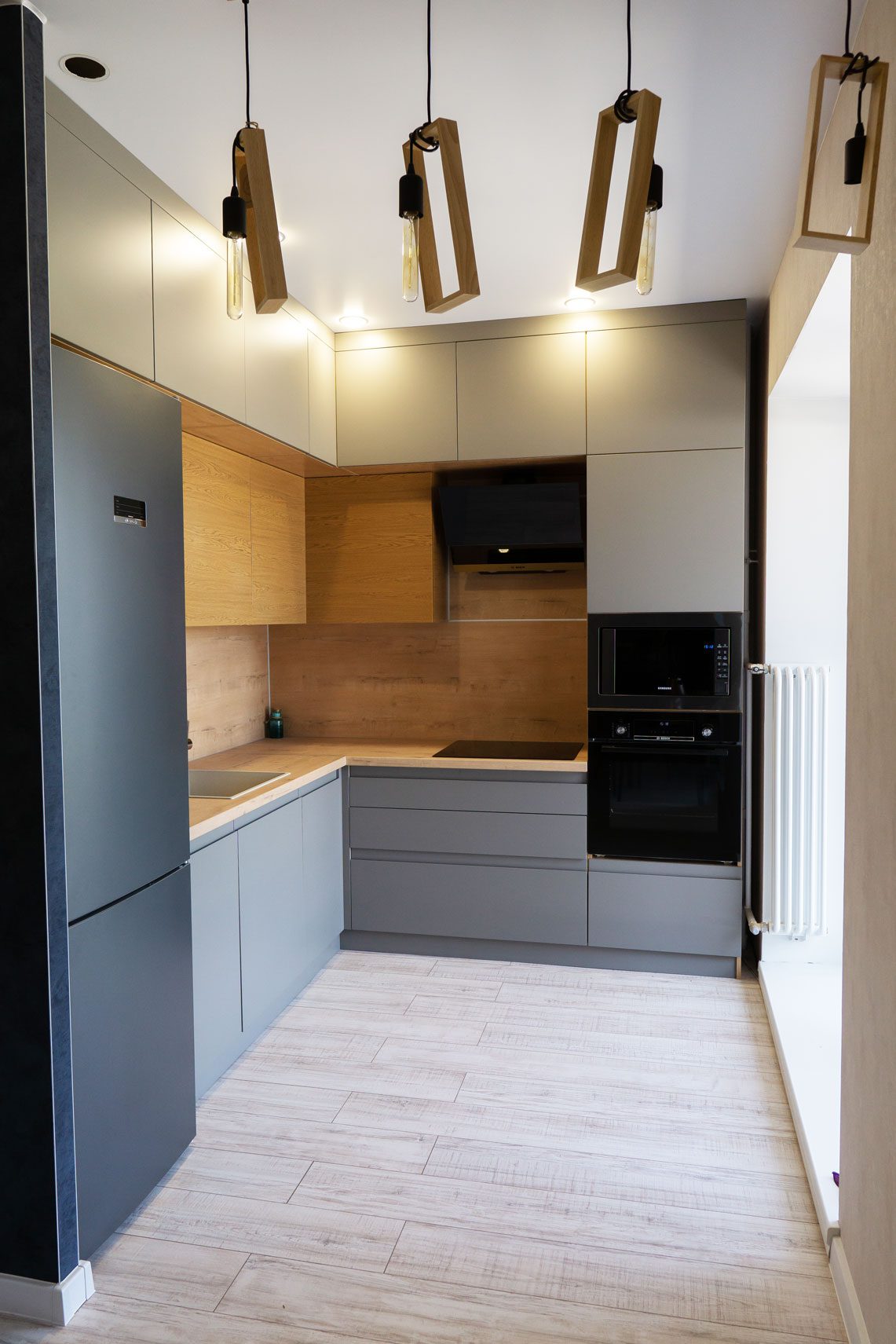 Современный дизайн кухни в серо-древесных тонах с оригинальными светильниками - пример ремонта кухни под ключ от компании 'Мастер Дома' в Томске.